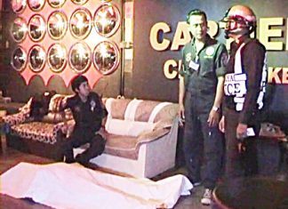 The body of Briton Anthony Rollins lies covered on the floor of the Cartier Karaoke as police wait to question staff members there.